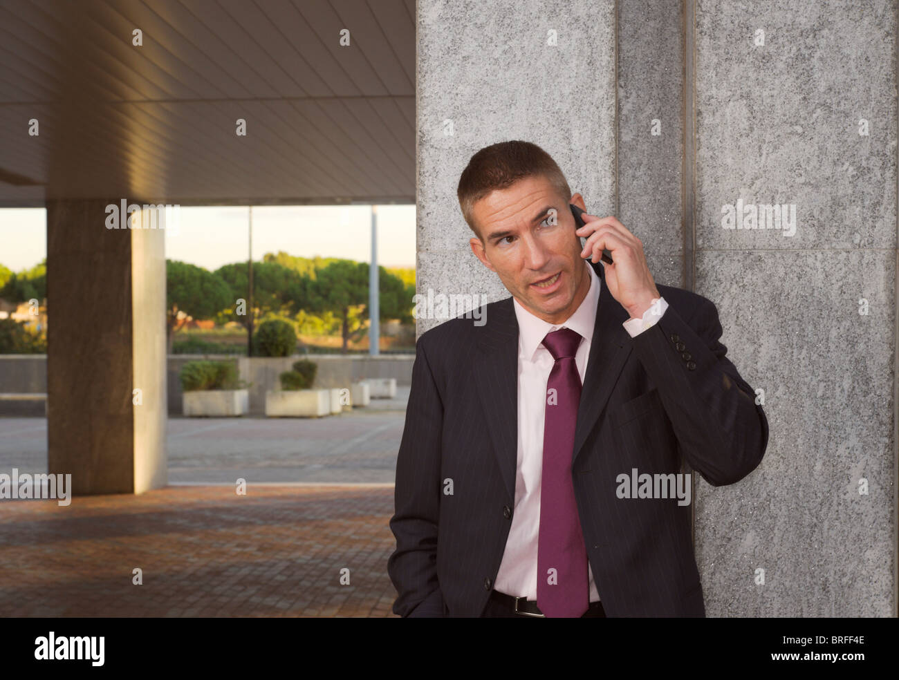 tough looking man in a suit, talking on mobile (cellular) phone, business concept Stock Photo