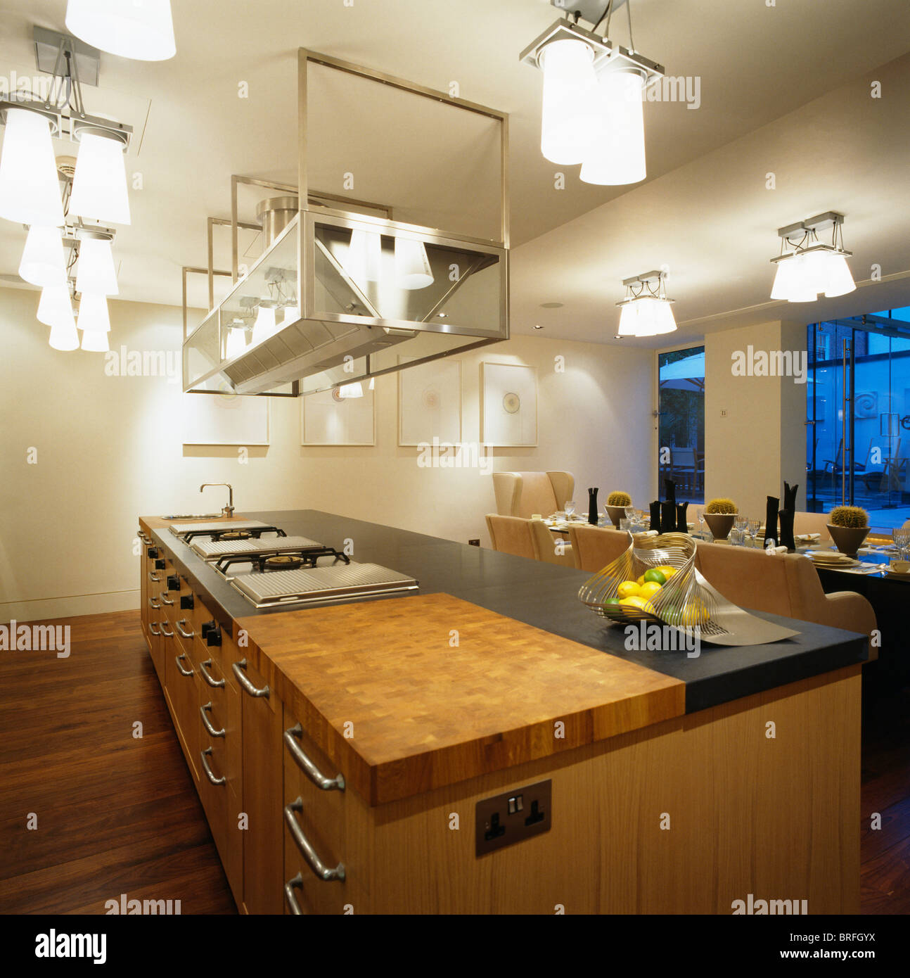 Suspended Stainless Steel Shelving And Ceiling Lights Above Island