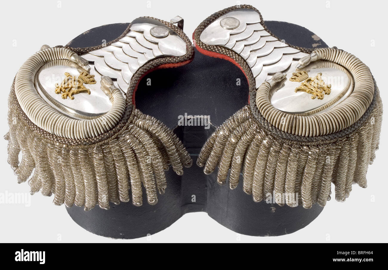 A pair of livery epaulets for a senior court servant,at the Royal Prussian Court. Silver-plated scales,fields with serpentine trim of strong,twisted wire,and overlain with the gilded cipher,'WR' and the royal crown. Silver bullions,red cloth backing. The star of the Order of the Black Eagle is stamped on the buttons. They come with the box. historic,historical,19th century,Prussian,Prussia,German,Germany,militaria,military,object,objects,stills,clipping,clippings,cut out,cut-out,cut-outs,utensil,piece of equipment,utensils,item,items,Additional-Rights-Clearences-Not Available Stock Photo