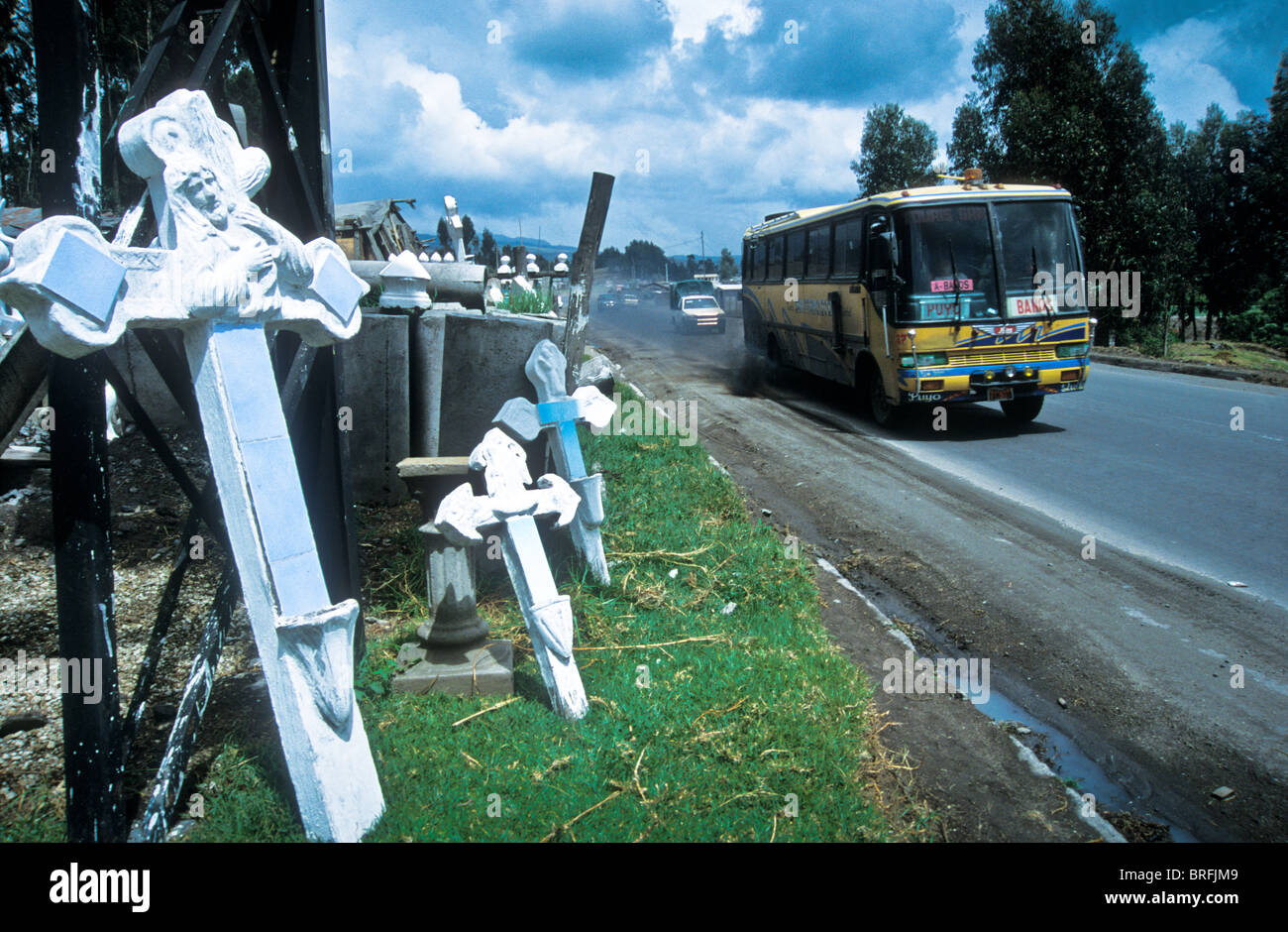 A long distance bus travels along the Panamerican Highway past a maker and seller of cemetry crucifixes Stock Photo