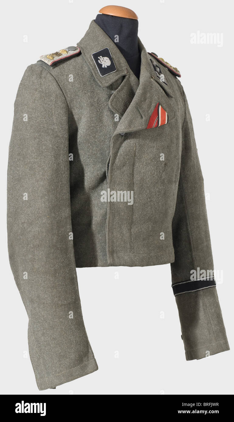 A field tunic for Hauptsturmführer,in the Assault Artillery Detachment of the 'Totenkopf'(Deaths Head)Division. Regulation issue of field grey wool fabric,grey lining with recognizable remnants of the size and supply stamps. Hand sewn insignia. Slip-on shoulder boards with a 'P' overlay,pink-coloured piping,black backing,and unattached to the wide enlisted men's loops. Black collar patches with silver cord,left displaying the rank insignia,the right a horizontal deaths head,embroidered in silver. Woven silver sleeve eagle on a black background. Black ,Additional-Rights-Clearences-Not Available Stock Photo