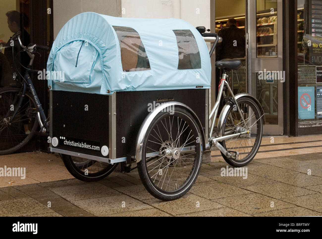 A cargo bike from the Danish firm Christiania, fitted out to transport  children, parked outside a Cambridge city centre store Stock Photo - Alamy