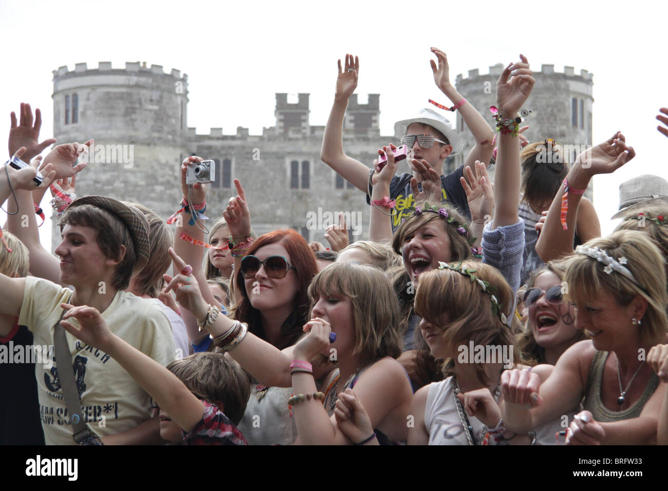 A crowd of children at Camp Bestival, the family friendly festival, go wild at the main stage. Lulworth Castle is behind. Stock Photo