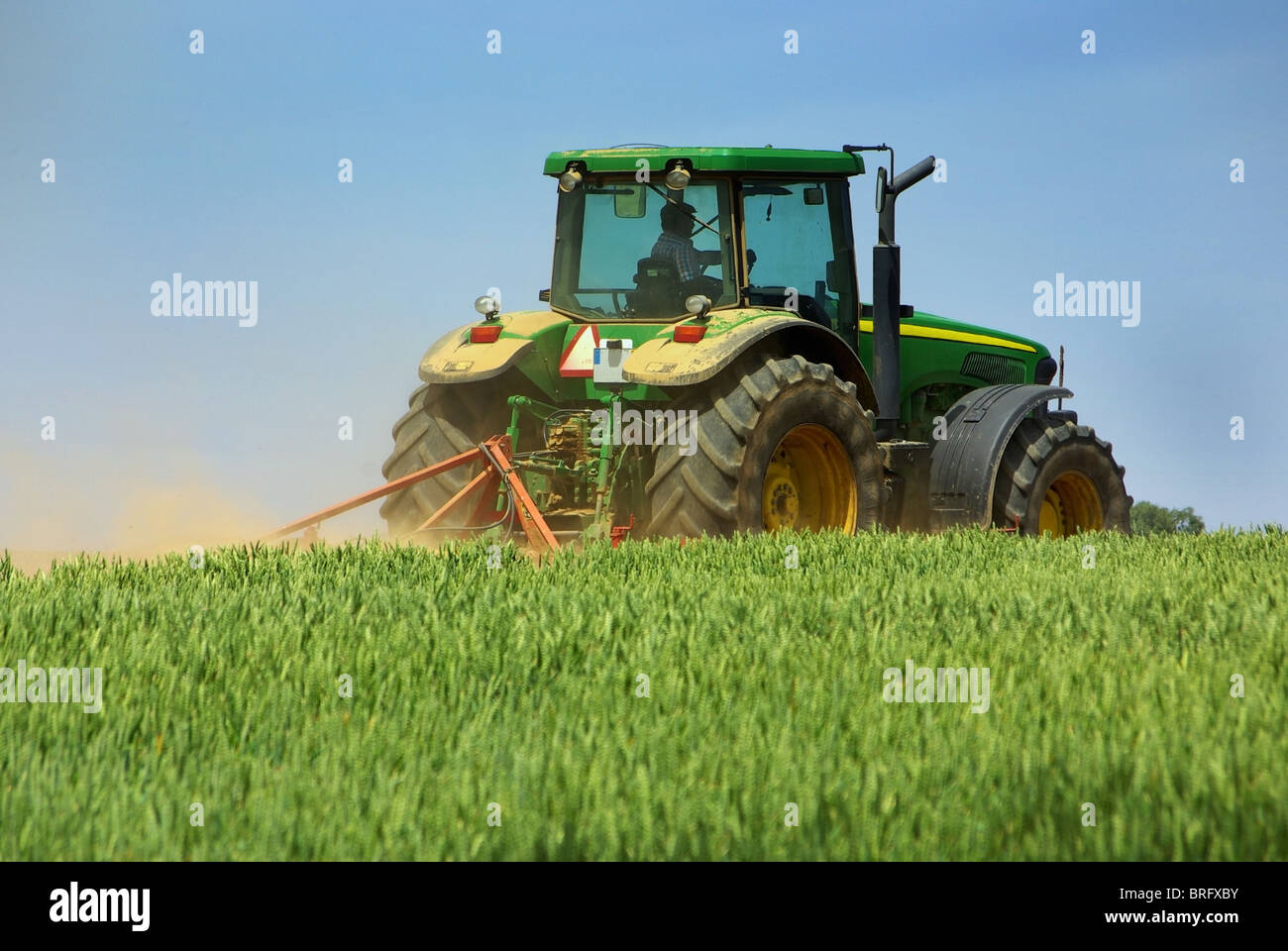 Green tractor in green field Stock Photo Alamy