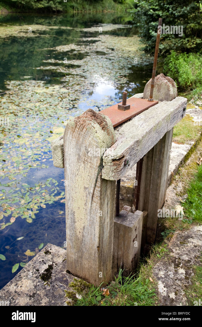 A wooden sluice gate governing the overflow from a mill pond Stock Photo
