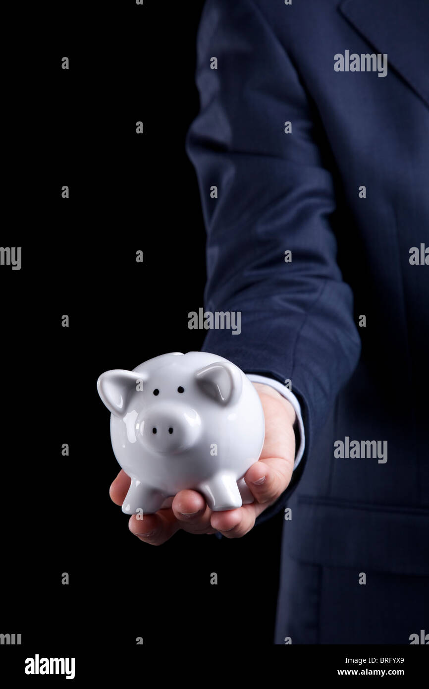 Businessman giving a piggy bank to you (isolated on black) Stock Photo