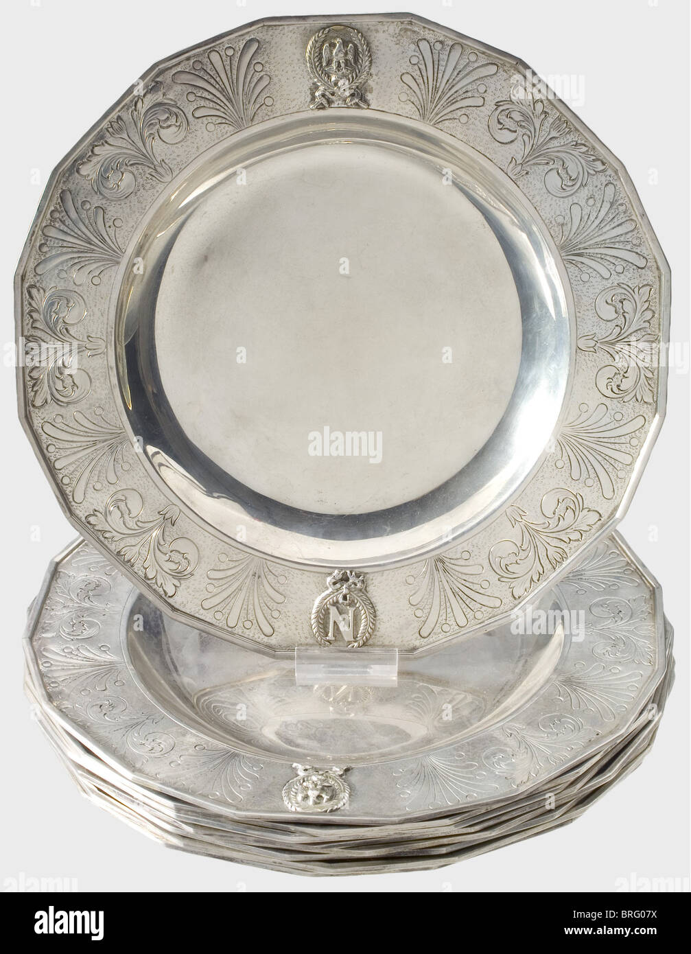 Nine silver plates, in the style of the First Empire, circa 1850. Vacant centres, the borders bear the soldered cipher 'N' in a laurel wreath and the imperial eagle amid engraved acanthus decorations. The edge molding is also soldered. The bottom displays the Parisian hallmark for the period 1798 - 1809 as well as the mark for the famous silversmith Jean Baptiste Claude Odiot (1763 - 1850). historic, historical, 19th century, dishes, dish, plate, plates, object, objects, stills, clipping, clippings, cut out, cut-out, cut-outs, Additional-Rights-Clearences-Not Available Stock Photo