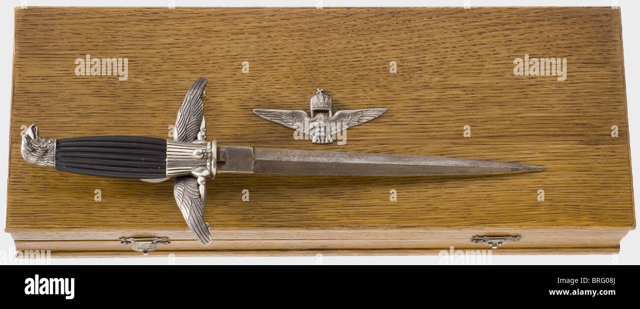 A pilot's honours dagger,in the 1938 pattern for NCOs and acting officers(silver colour).A partially gilded dagger blade with decorative etching and a dedication inscription on the reverse side,'5.légigyözelemed emlékére'(In commemoration of the 5th Air Victory).The ricasso bears the maker's mark 'HH'.Silver eagle's head pommel,silver quillons,and silver turul(heraldic falcon from Hungarian mythology)taking flight,each bear the '800' hallmark.Ribbed ebony grip.Length 33.5 cm.Silver scabbard bears the national coat of arms and the '800' hallmark.,Additional-Rights-Clearences-Not Available Stock Photo