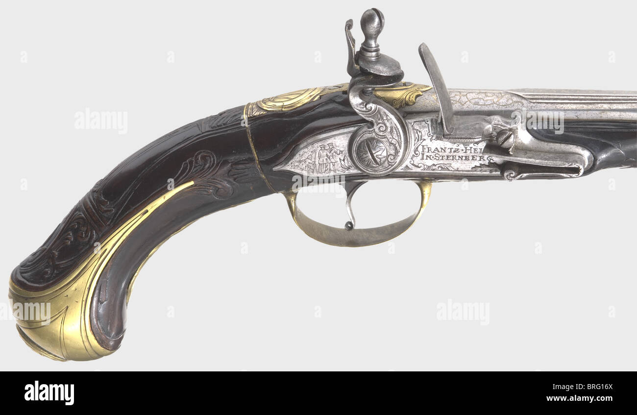 A muzzle-loading air pistol,Franz Heinz,Sternberg/Moravia,circa 1730.Round barrel with sighting flat and brass insert in 9 mm calibre.Silver inlaid vine decoration and the signature "FRANTZ HEINZ" on the base of the barrel.Engraved simulated flintlock with an additional signature and the inscription "IN STERNBERG".Carved walnut stock with a screw-in buttstock and air reservoir.Brass furniture.The lock plate displays relief engravings of hunting themes.Original wooden ramrod with brass tip.Length 52 cm.Franz Heinz,Sternberg in Moravia,ca.1690 - 17,Additional-Rights-Clearences-Not Available Stock Photo