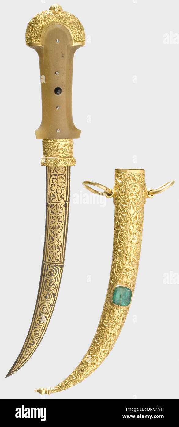 A golden Moroccan presentation koummya,circa 1900.Typically curved blade with a double-edged point,and entirely covered with gold-inlaid geometric ornamentation on both sides.Mountings and scabbard are of engraved massive gold.Rhinoceros horn grip with four small diamonds and a small red jewel set into the obverse side.Massive gold scabbard with two suspension rings.The obverse side is set with a large emerald(ca.10 x 10 mm).Length 27.5 cm.Total gold weight ca.150 g.Weight of the scabbard 127 g.historic,historical,1900s,20th century,19th centu,Additional-Rights-Clearences-Not Available Stock Photo