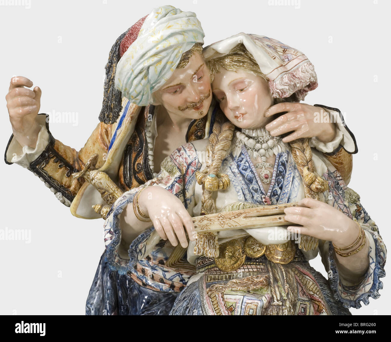 A Viennese faience figures sculpture, Goldscheider(?) Company, circa 1870 A couple in Bosnian costumes leaning on a rock, modelled in detail in full relief, and colour painted. The man has a yataghan and two pistols in his belt, the woman is holding a flute. Floral decorated, high plinth, numbered '627' and '8' on the back and bearing the inscription (transl.), 'Protected by Law, Copies Reserved'. Except for a small chip or restoration respectively on the lower edge of the plinth, in perfect condition, presumably, the man originally held a spear or so, Artist's Copyright has not to be cleared Stock Photo