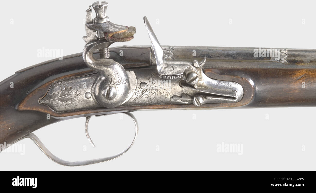 A pair of boy's flintlock pistols,Johann Krach in Ebenau near Salzburg,circa 1660.Blued,smooth bore barrels in 10 mm calibre,octagonal,then 16-sided,then becoming round after cut balusters,divided into sections by bands of leafy friezes.The gun maker's signature 'Johann Krach' is engraved on the breeches.Cambered lock plates with engraved floral and leaf decoration.Smooth walnut stocks with the armoury number '36'.Silver furniture engraved with floral designs.The side plates are shaped as monsters.Lengths 43.5 cm.Johann Krach,known 1636 - 86,wo,Additional-Rights-Clearences-Not Available Stock Photo