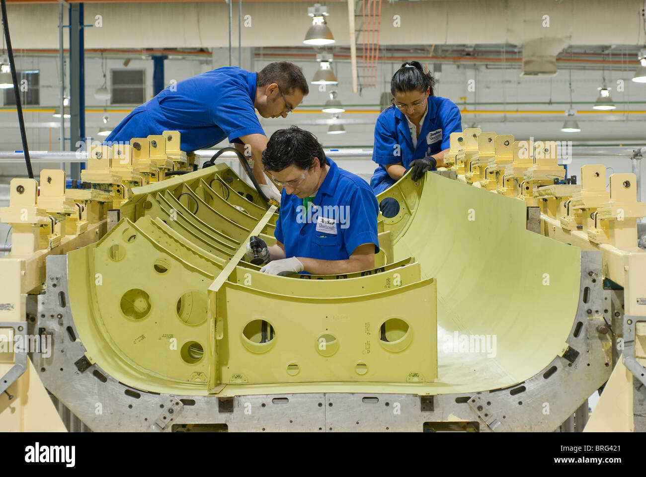 Workers at the Hawker Beechcraft aerospace plant in Chihuahua, Mexico construct jet airplane parts for export to the USA. Stock Photo