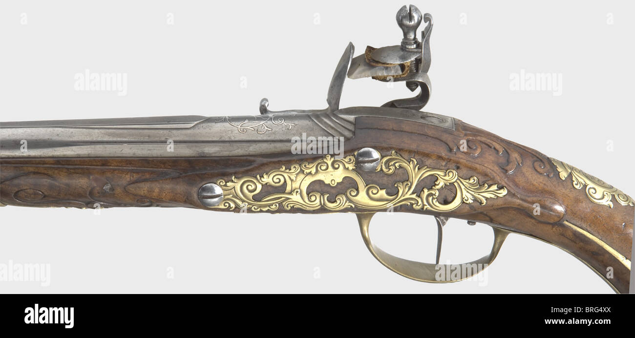 A flintlock pistol,Johann Martin Felber,Ravensburg,circa 1730.Barrel flat on the sides then becoming round,with smooth bore in 15 mm calibre,and with a brass front sight on the barrel rib.Silver-inlaid ornamentation above the breech.The flintlock is finely engraved with hunting and floral designs,and bears the signature,'JOHANN MARTIN FELBER' around the powder pan.Single set trigger.Carved walnut stock with horn nose cap.Beautifully engraved brass furniture with an openwork side plate.Original wooden ramrod with horn tip.Elegant,well preserved p,Additional-Rights-Clearences-Not Available Stock Photo