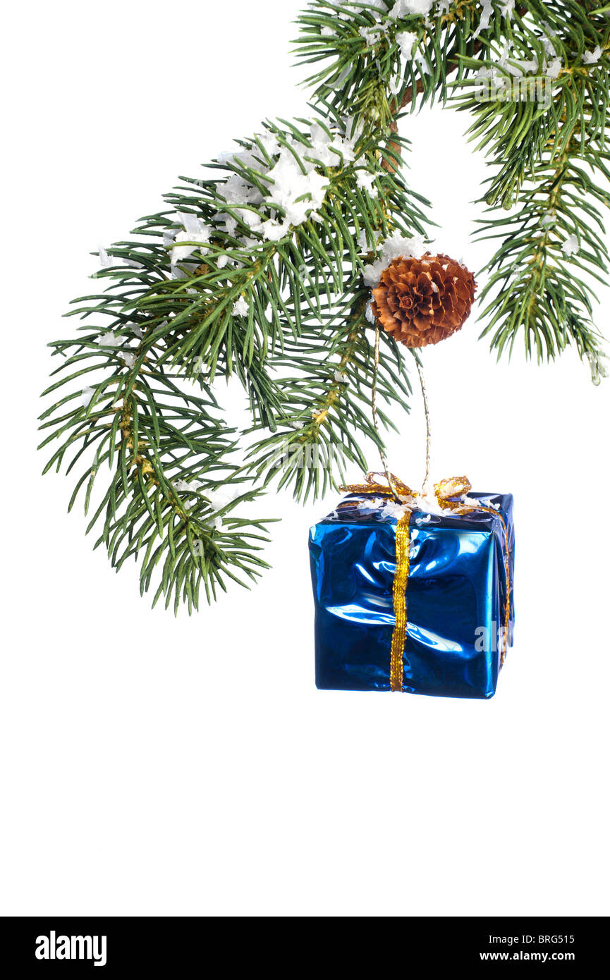 A Christmas gift ornament hanging from an artificial snow covered pine tree branch. Stock Photo