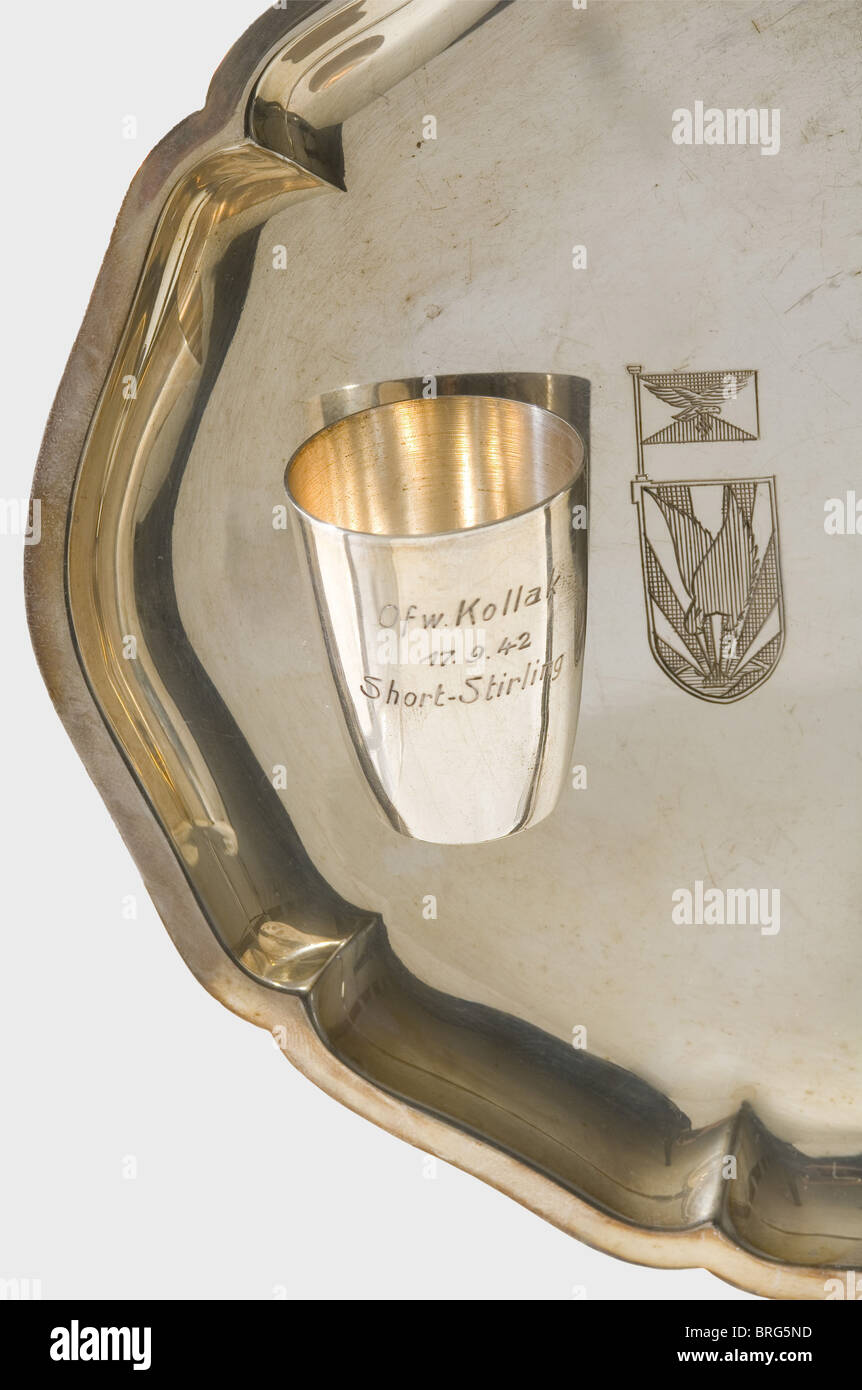 Stabsfeldwebel Reinhard Kollak,Night Fighter in Night Fighter Squadrons 1 and 4,27 victory tumblers and kill confirmations for 27 air victories as a night fighter 1941 - 1944.Belgian/French silver tumblers in nearly identical designs,the obverses are engraved with service grade(Tech.Sgt.,Master Sgt.= Fw for Feldwebel and Ofw for Oberfeldwebel),'Kollak',date of victory and type of aircraft shot down,with silver hallmark in the base.Height each 40 - 45 mm.On three silver tablets with the engraved emblem of the night fighter squadron or division.Tota,Additional-Rights-Clearences-Not Available Stock Photo