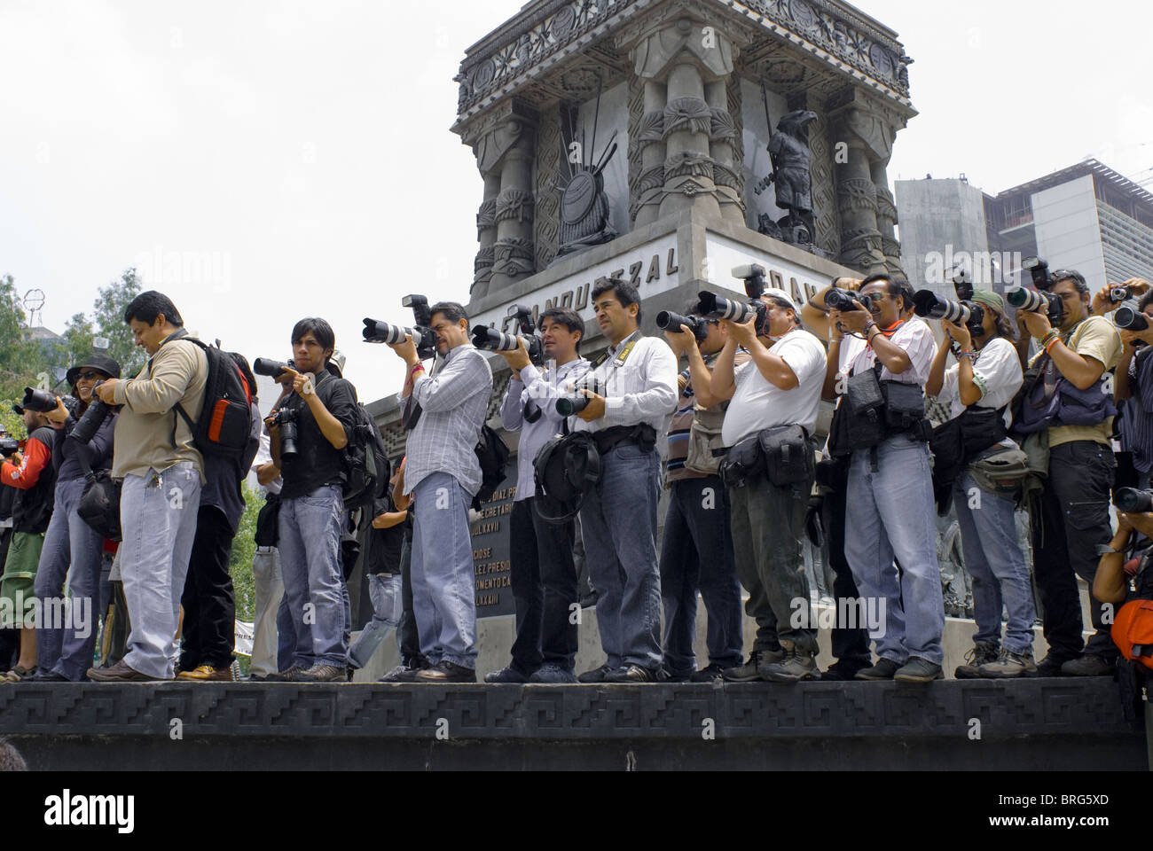 Photographers covering the journalist march of silence line up for a shot by the statue of Aztec emperor, Cuauhtémoc. Stock Photo