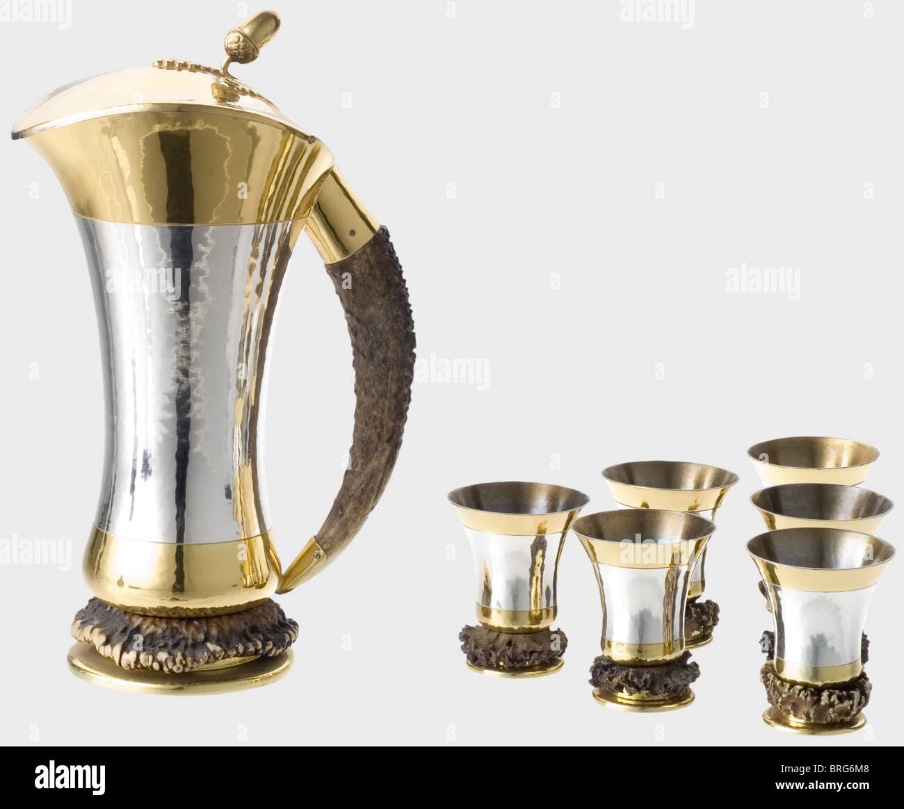 Hermann Göring,a hunter's drinking set Gilded silver hunting tankard.Hand hammered silver,with gilded base,lid,and edge of the lip.Antler tine as a handle.Massive antler rosette on the base.The lid bears a sculpted acorn and oak leaves in relief.Marked "Handarbeit","925" next to a crescent moon and crown,"HW",and "Sterling" on the bottom.Height 23 cm.Weight 654 g.Also six matching beakers in the same style and with the same marks.Heights 61 mm.Weights 56 to 62.5 g.To our knowledge this is part of a larger set,which Hermann Göring received on ,Additional-Rights-Clearences-Not Available Stock Photo