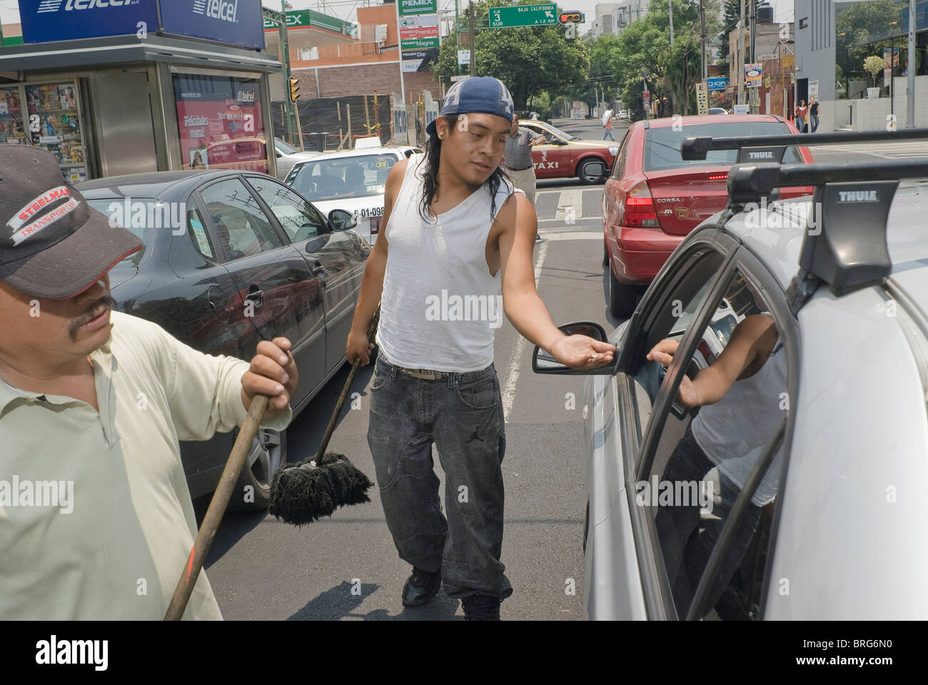 The street remains the last refuge of the unemployed, like these dust mop car cleaners in Mexico City. Stock Photo