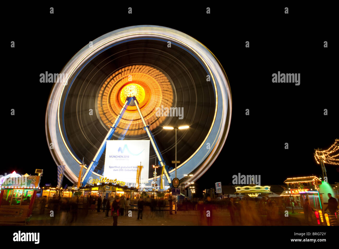 Ferris wheel with motion blur lit up at night at the Oktoberfest ...