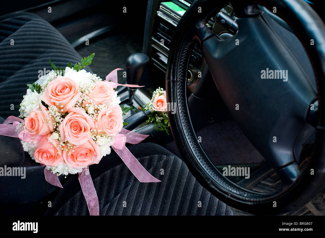 brides bouquet inside a car between front seats Stock Photo