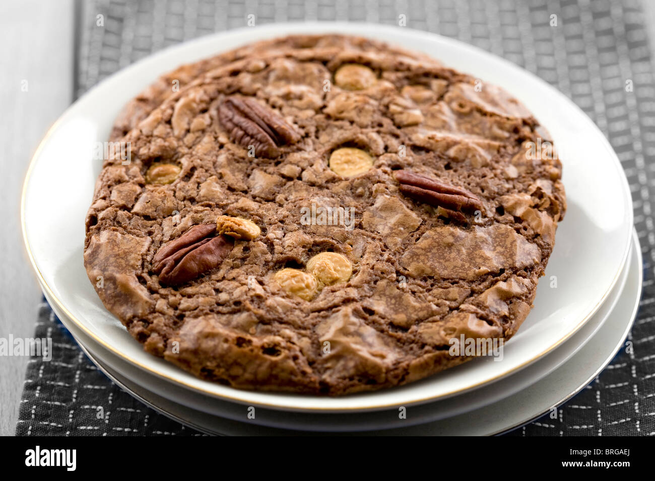 giant pecan and white chocolate cookie on a monochrome background Stock Photo