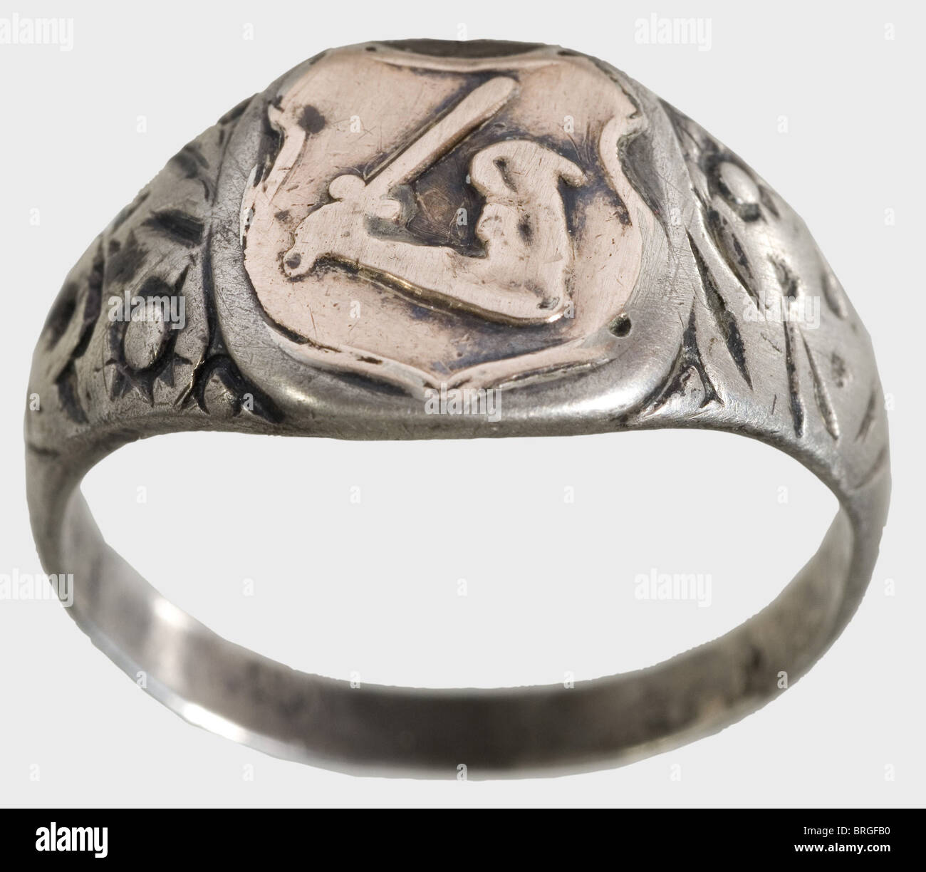 A SS death's-head ring,and a heraldic ring of the Estonian Legion Silver,custom-made issue of the jeweller Gahr in Munich with separately soldered-on death's head. On the inside surface the engraved dedication: 'S.lb. Wonerat 21.6.42. H. Himmler'. Included is a silver ring with a superimposed golden coat of arms of the Estonian Legion. Marks of fineness. Both rings with signs of wear and traces of acid cleaning. Weight 11.5 and 6.5 g respectively.,historic,historical,1930s,1930s,20th century,Waffen-SS,armed division of the SS,armed service,armed serv,Additional-Rights-Clearences-Not Available Stock Photo