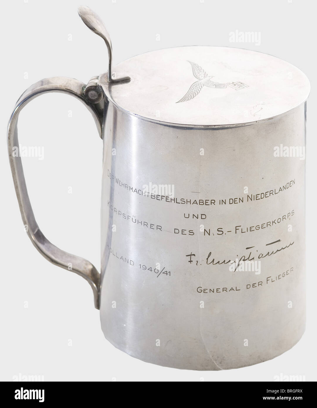 Fregattenkapitän Carl Christiansen(1884 - 1969),a silver gift tankard from his brother Friedrich Christiansen Tapers slightly toward top with an engraving on right side,'Der Wehrmachtsbefehlhaber in den Niederlanden und Korpsführer des N.S.Fliegerkorps Holland 1940/41 - Fr.Christiansen Gerneral der Flieger.'(The Wehrmacht Commander in Netherlands and Corps Commander of N.S.Flying Corps Holland 1940/41 - Fr.Christiansen General der Flieger).On left side there is a finely engraved view of a village with lighthouse on beach at t,Additional-Rights-Clearences-Not Available Stock Photo