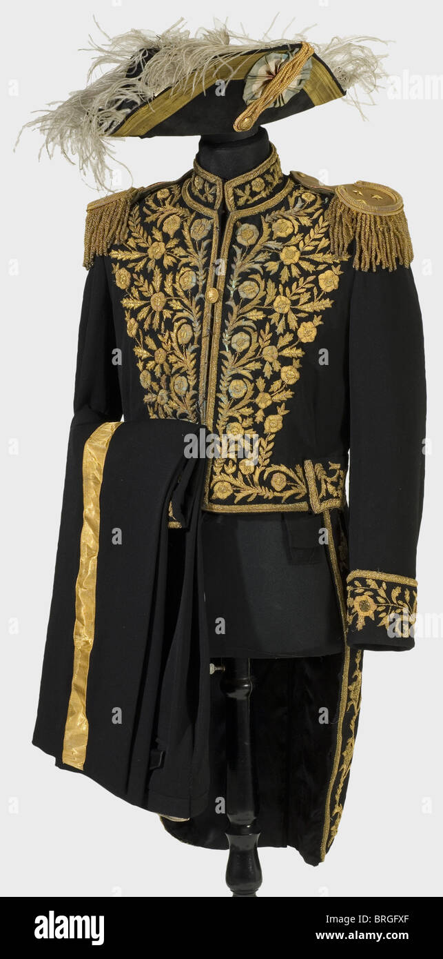 An Iranian diplomatic uniform, circa 1930 Cocked hat of black velvet with gold lace and loop, silk cockade. Tail coat of black cloth with golden metal embroidery of floral designs, golden epaulettes with olive-green wool backing. Matching trousers with broad golden leg stripes. Beautiful cloth, embroidery and epaulettes have traces of age and wear., historic, historical, 1930s, 20th century, object, objects, stills, clipping, clippings, cut out, cut-out, cut-outs, uniform, uniforms, outfit, outfits, textile, clothes, Additional-Rights-Clearences-Not Available Stock Photo