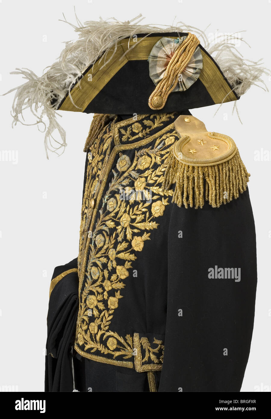 An Iranian diplomatic uniform, circa 1930 Cocked hat of black velvet with gold lace and loop, silk cockade. Tail coat of black cloth with golden metal embroidery of floral designs, golden epaulettes with olive-green wool backing. Matching trousers with broad golden leg stripes. Beautiful cloth, embroidery and epaulettes have traces of age and wear., historic, historical, 1930s, 20th century, object, objects, stills, clipping, clippings, cut out, cut-out, cut-outs, uniform, uniforms, outfit, outfits, textile, clothes, Additional-Rights-Clearences-Not Available Stock Photo