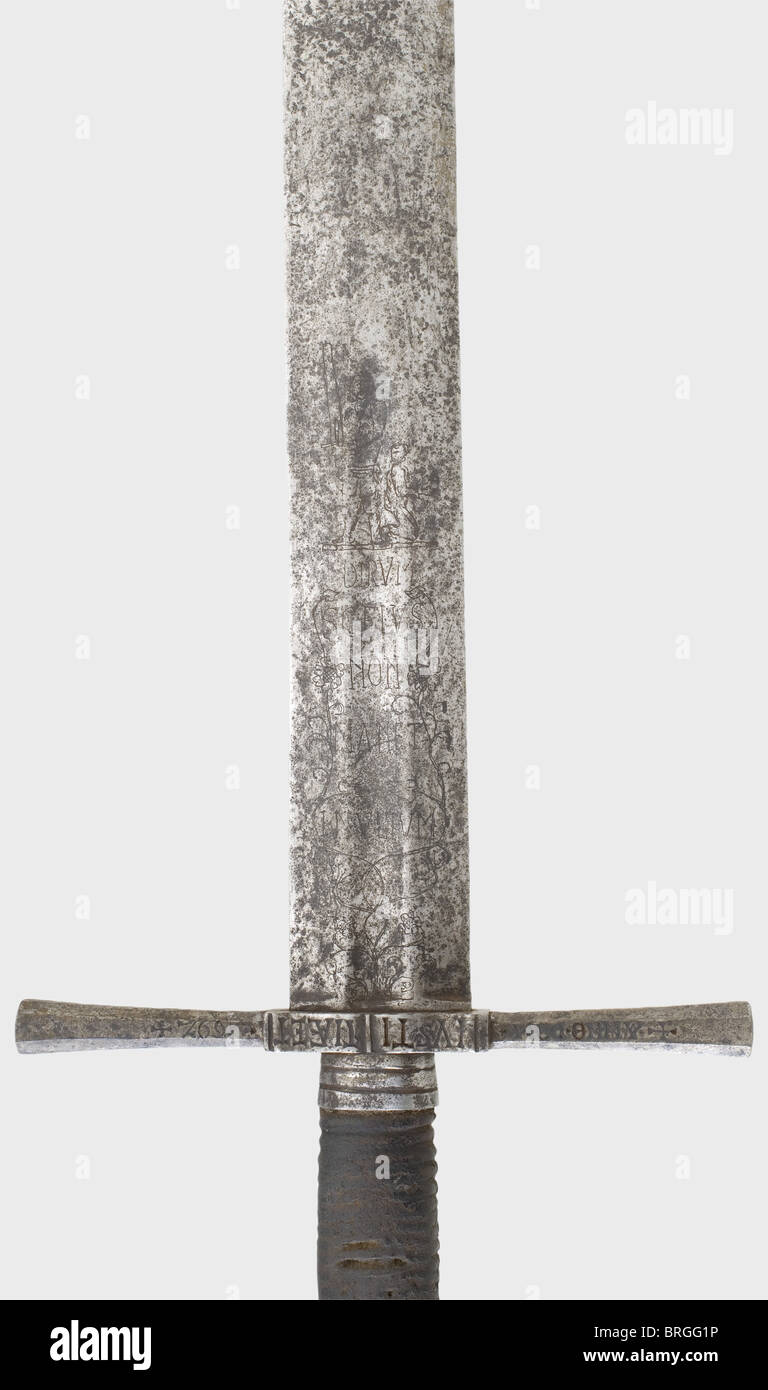 A German executioner's sword,dated 1692 Heavy,double-edged blade with an imperial orb mark at the base and triple holes at the point.Both sides of the upper quarter have fullers and bear decorative etching of floral designs,Justitia,an execution scene,and Latin inscriptions.Iron quillons with inscriptions on both sides.'+MERT*HEKEL*CARNIFEX+ANNO.DOM*1692+ and 'IUSTITIA ET LEGE SERVO'(Mert Hekel,Executioner Anno Domini 1692 - I serve justice and the law).Pear shaped,faceted iron pommel with later grip cover of leather over cord winding.Iron parts ar,Additional-Rights-Clearences-Not Available Stock Photo