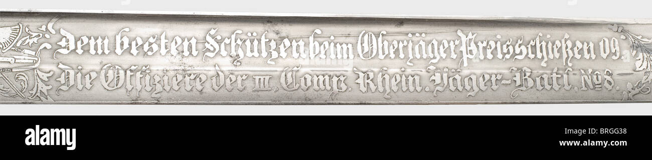 A shooting prize hunting hanger for the year 1909,of the Rhenish Jäger Battalion No.8 Richly etched single-edged blade with a double-edged point,the obverse side bearing the dedication inscription,'To the best shot in the Oberjäger shooting competition 09.The officers of the III Company of the Rhenish Jäger Battalion No.8'(transl.),the reverse side red deer,each separated by floral decoration,trophies,and stags.The back is etched 'Weyersberg & Co.Solingen'.Brass hilt with a clamshell guard plate,and a staghorn grip bearing three acorns.Black lea,Additional-Rights-Clearences-Not Available Stock Photo