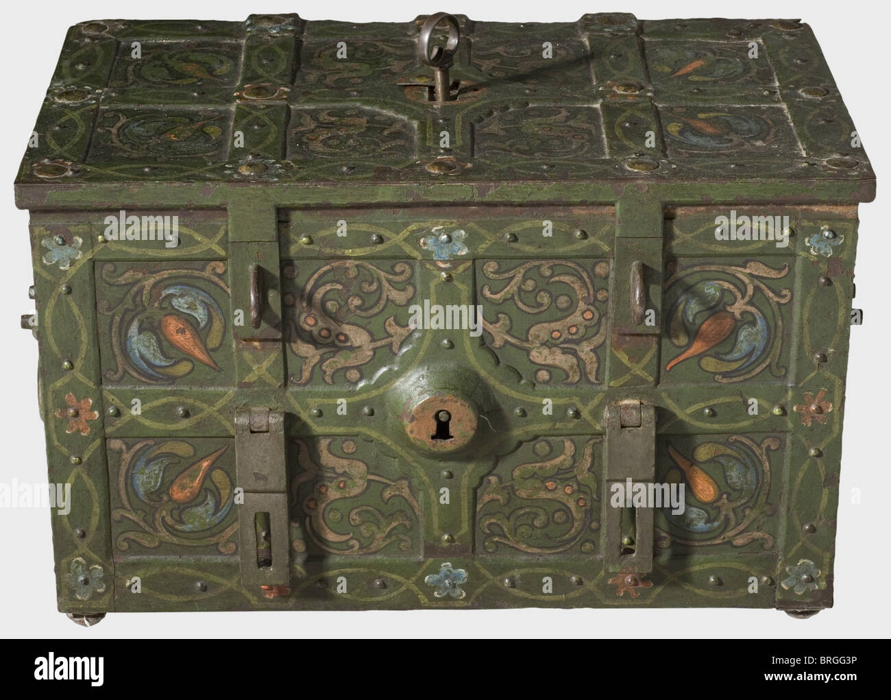 A German war chest painted in colour,2nd half of the 17th century Rectangular iron trunk with flattened ball feet and riveted,crossed strap fittings.The lid has a covered central keyhole.On the front a false lock with an embossed keyhole cover and two hasps.Movable carrying handles on the sides.Original colour paint with vine decoration.The lock in the lid(ward missing)with ten latches worked over the corners.The open work,screw fastened lock cover is richly provided with curved bands(four of the ball-headed screws missing).The interior is lined wi,Additional-Rights-Clearences-Not Available Stock Photo