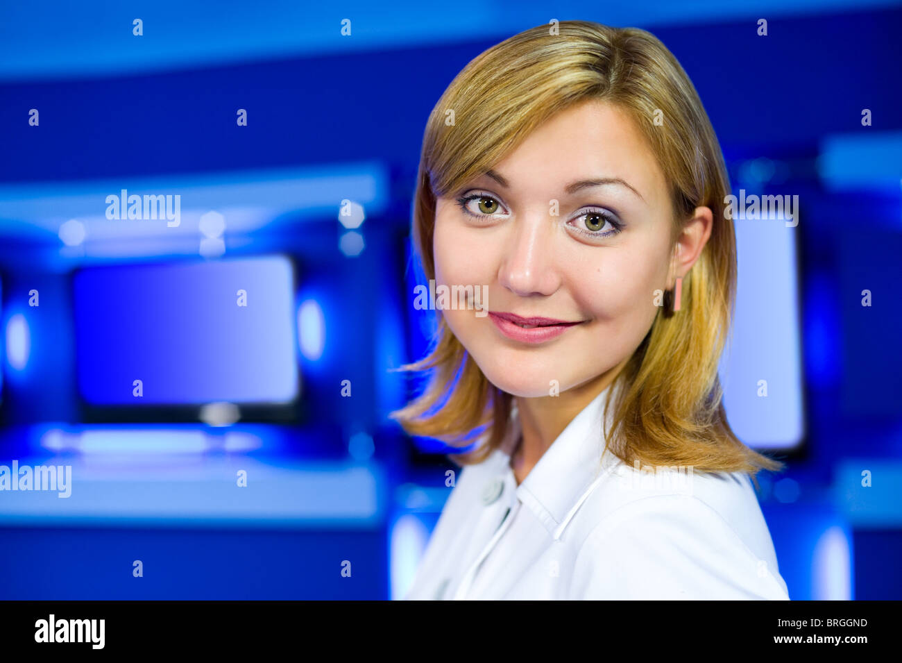 a television anchorwoman at studio smiles into camera Stock Photo