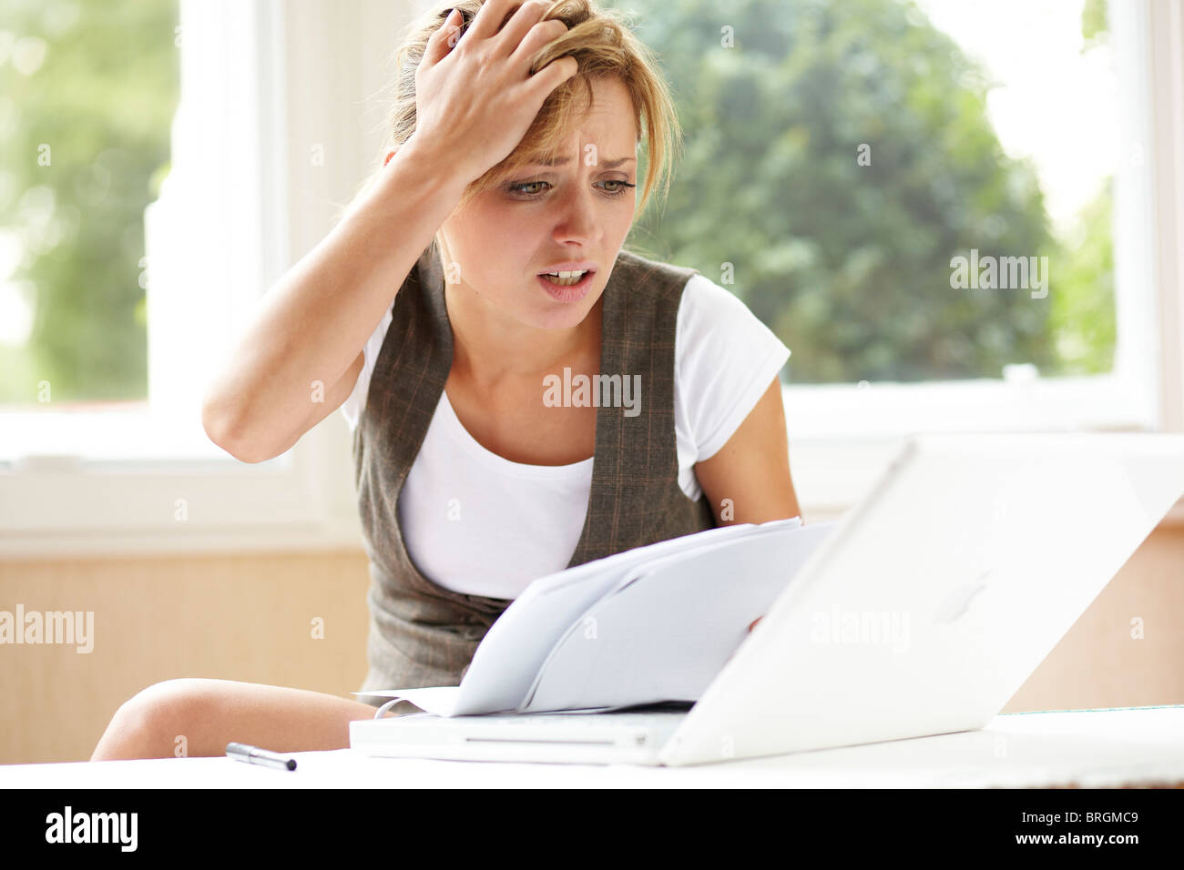Stressed girl looking at bills Stock Photo