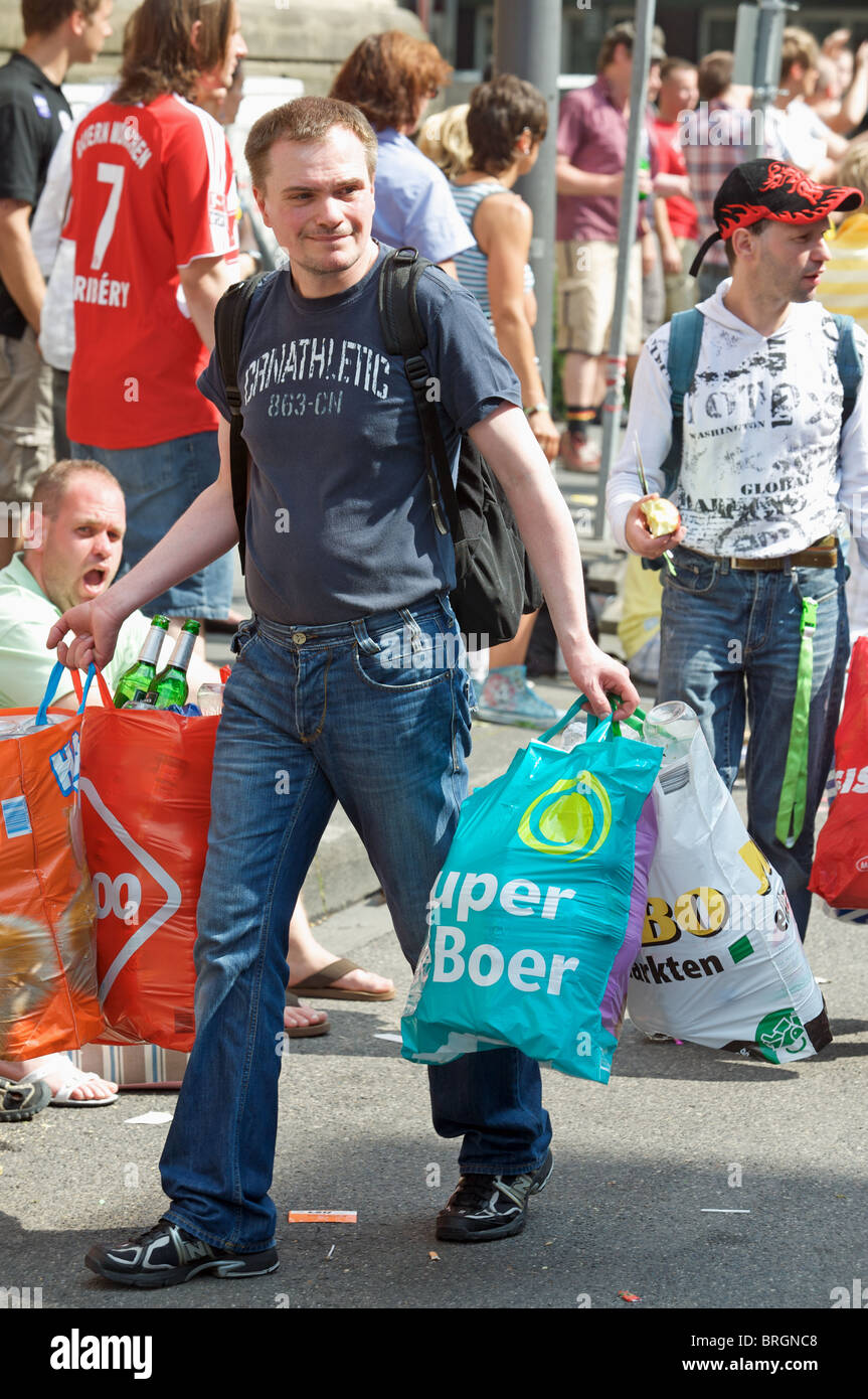 Jobless man collecting glass bottles after a street fair, Cologne, Germany. Stock Photo