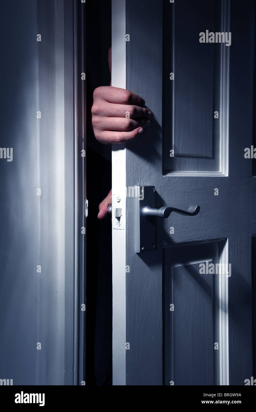 Hands appearing through a slightly open door Stock Photo