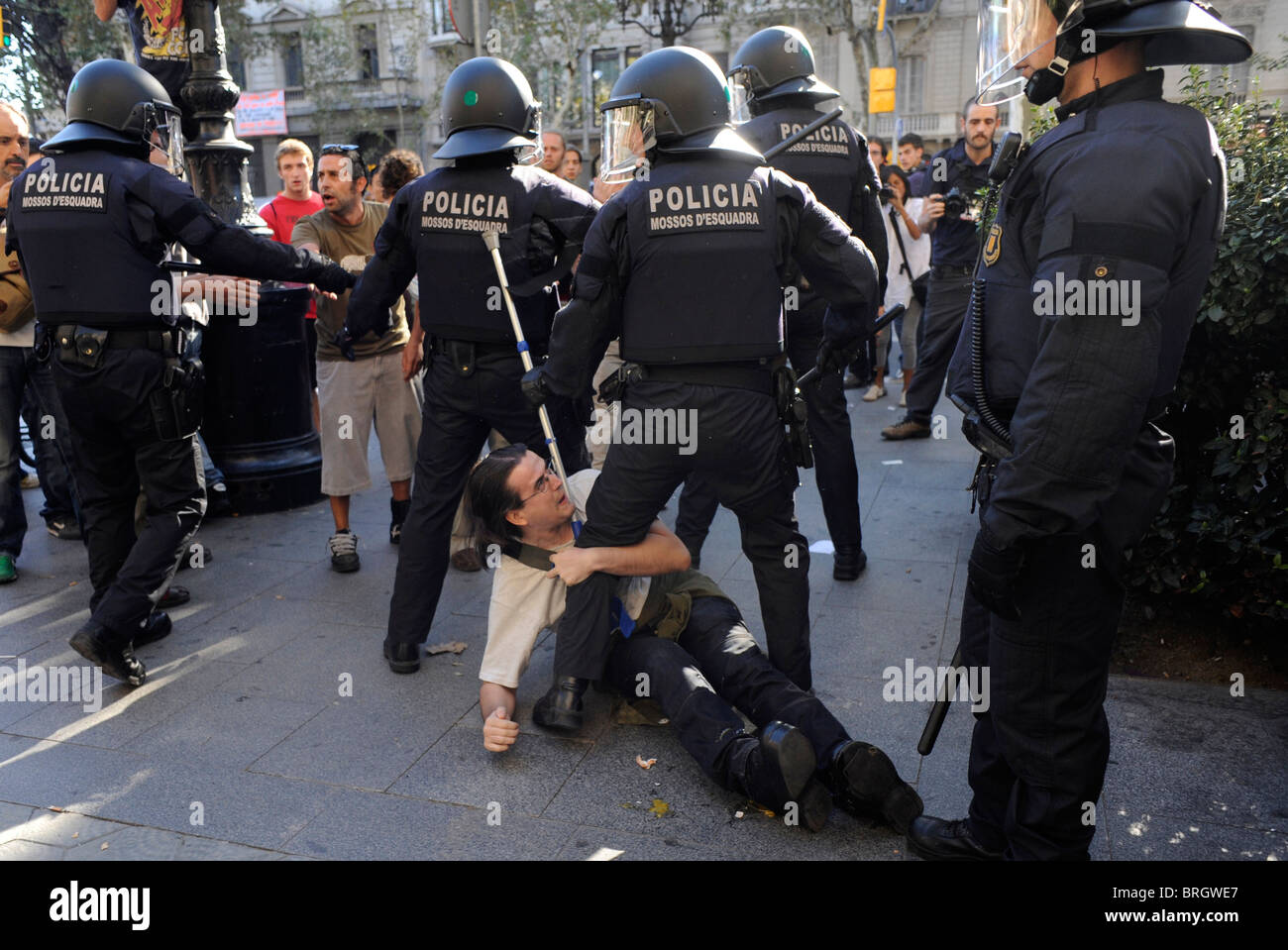 Protesters face  anti riot police in the clashes at the city center during the general strike in Barcelona.Spain. Stock Photo