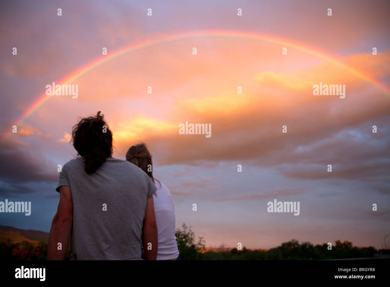 A couple viewing a rainbow at sunset in Boise, Idaho, USA. Stock Photo