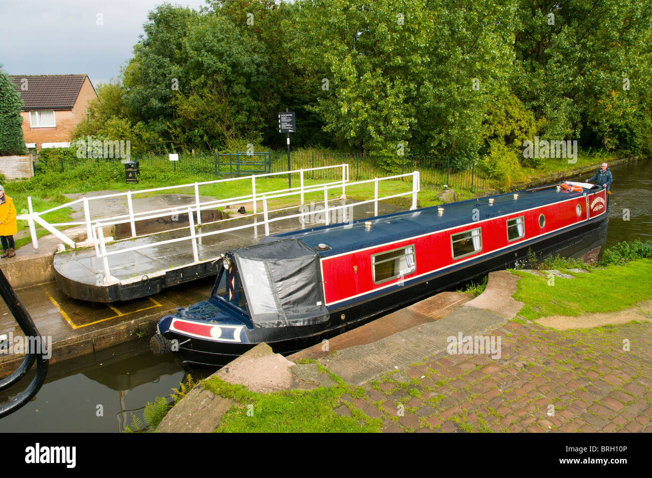 A canal narrowboat passing a swing bridge on the Ashton canal at Droylsden, Tameside, Manchester, England, UK Stock Photo