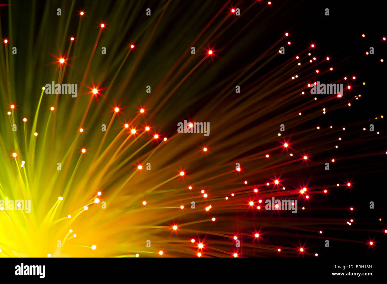 closeup on illuminated orange optic fibers under black background Stock