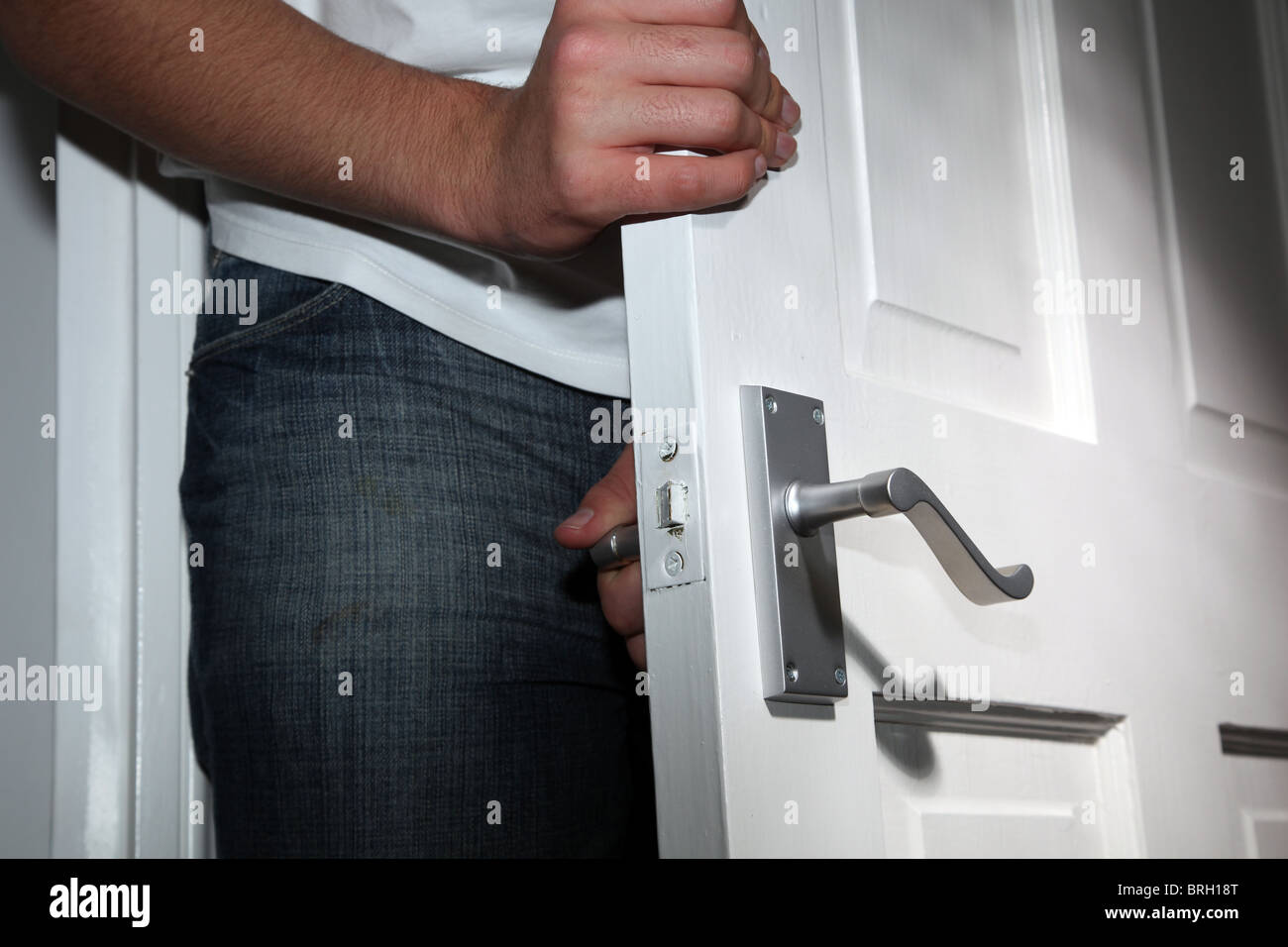 Male figure entering a dark room, face not showing Stock Photo