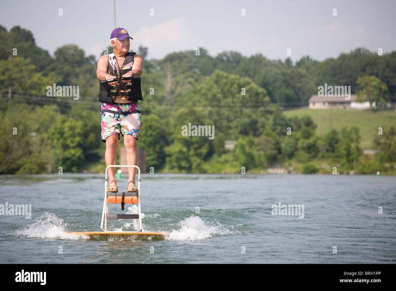 Senior citizen water skiing on a Tennessee lake, using a ladder