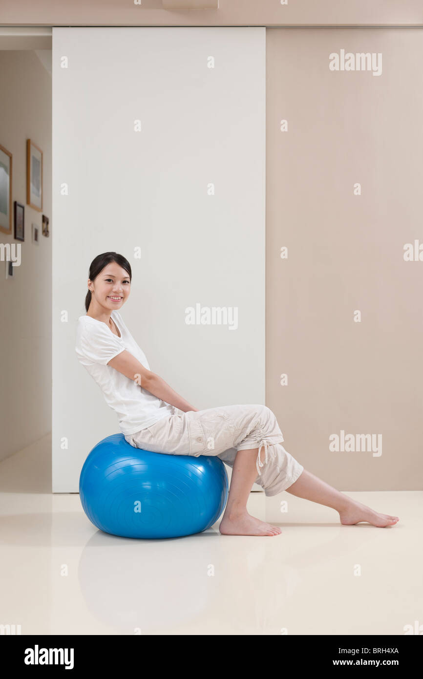 Young woman sitting on a gymnastic ball Stock Photo - Alamy