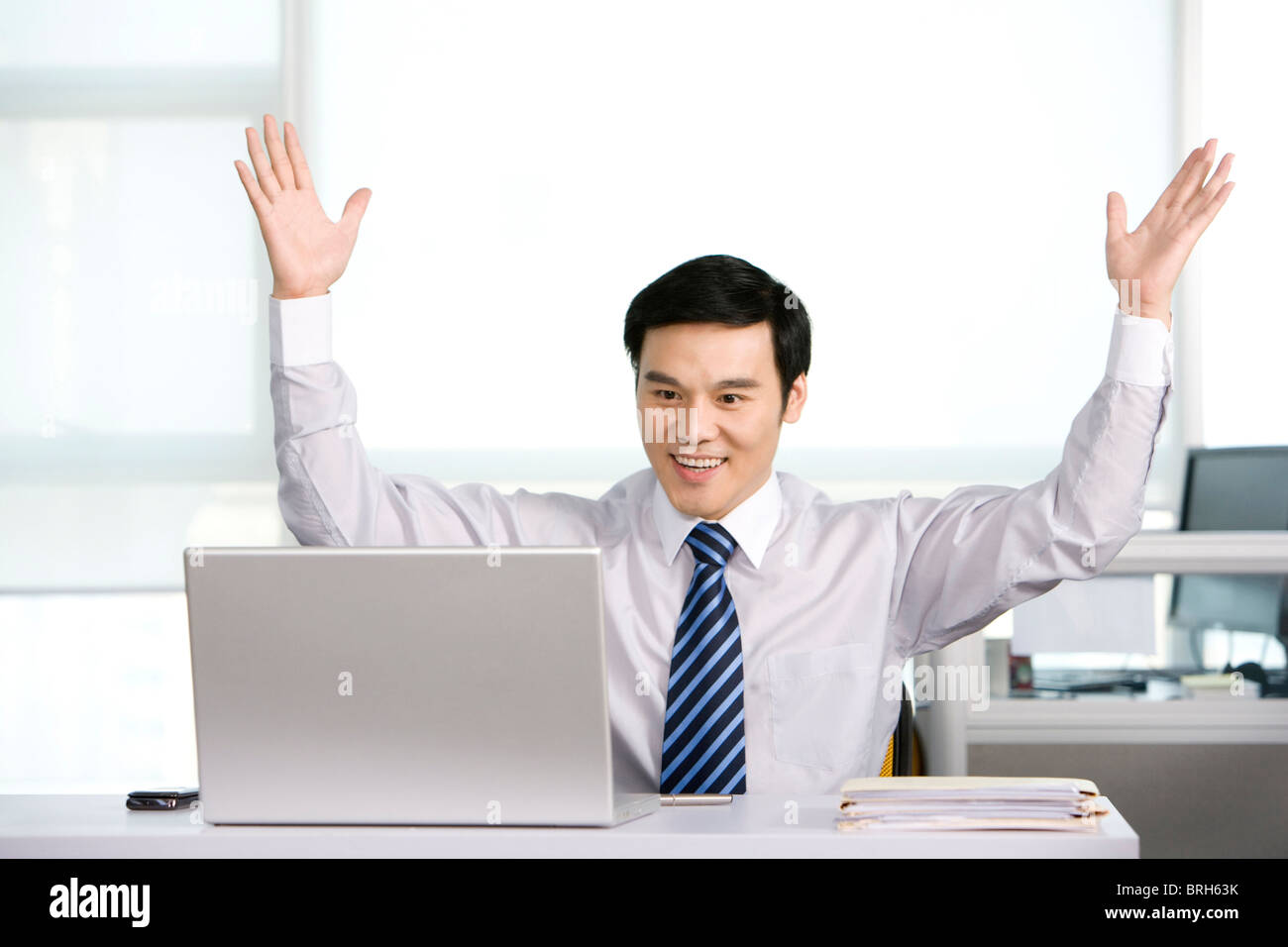 Happy office worker at his desk Stock Photo - Alamy