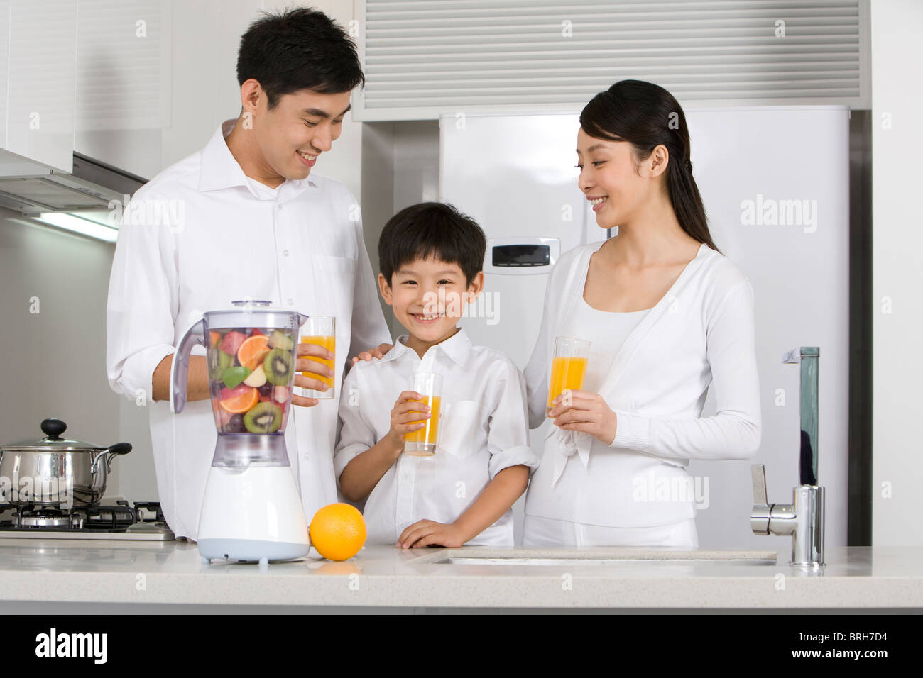 Family drinking fresh fruit juice in kitchen Stock Photo Alamy
