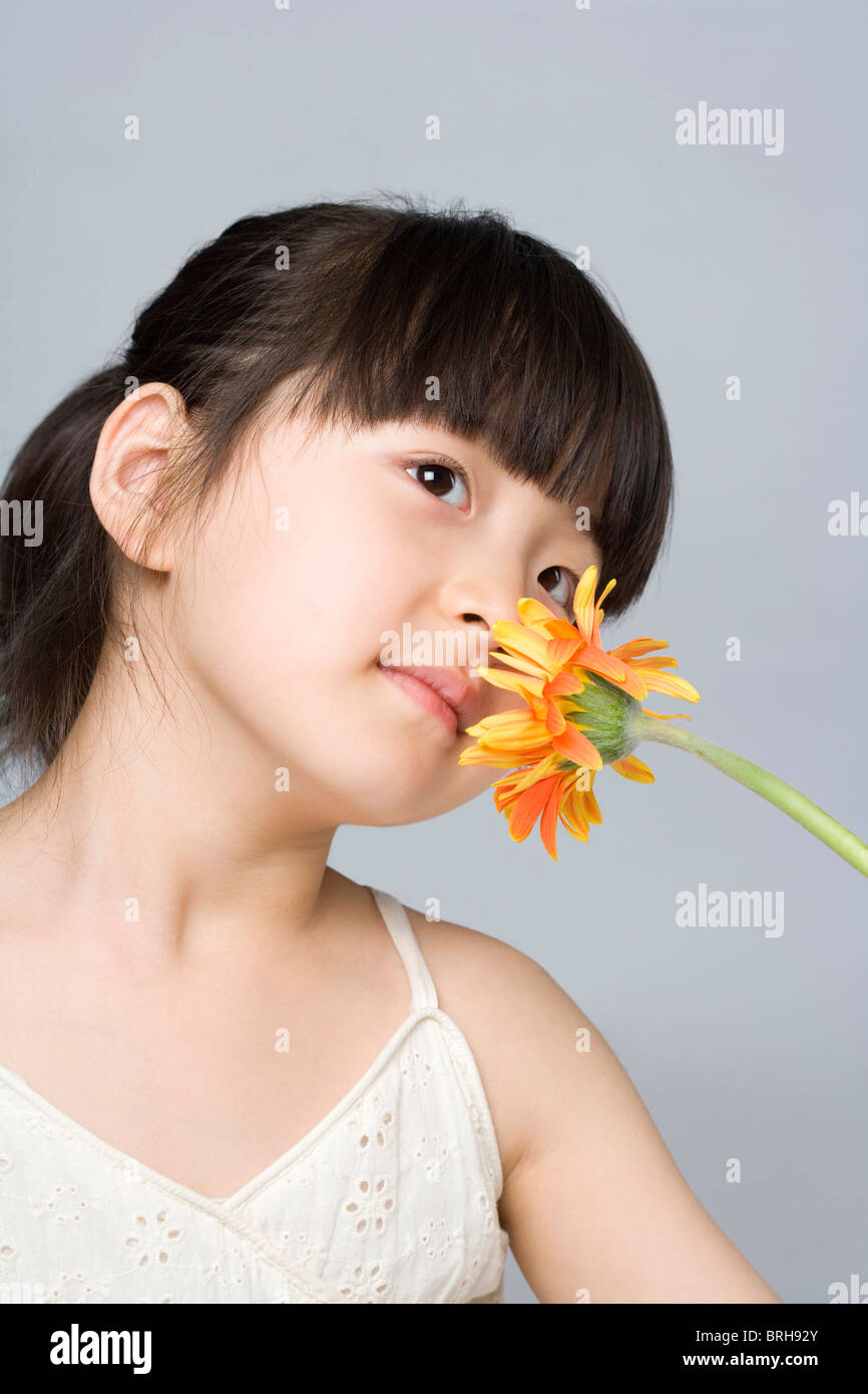 Little girl smelling a flower Stock Photo - Alamy
