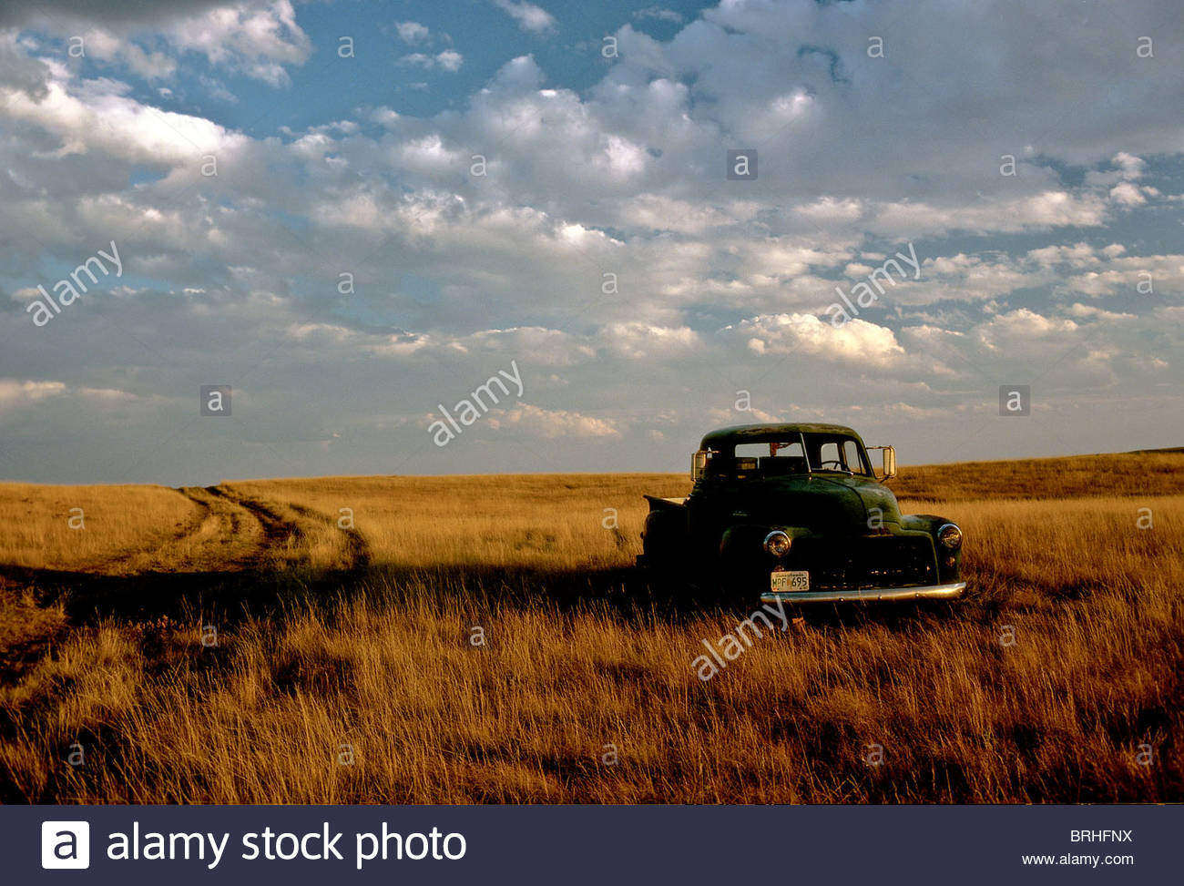 A landscape of an old farm truck in a field at sunset Stock Photo - Alamy