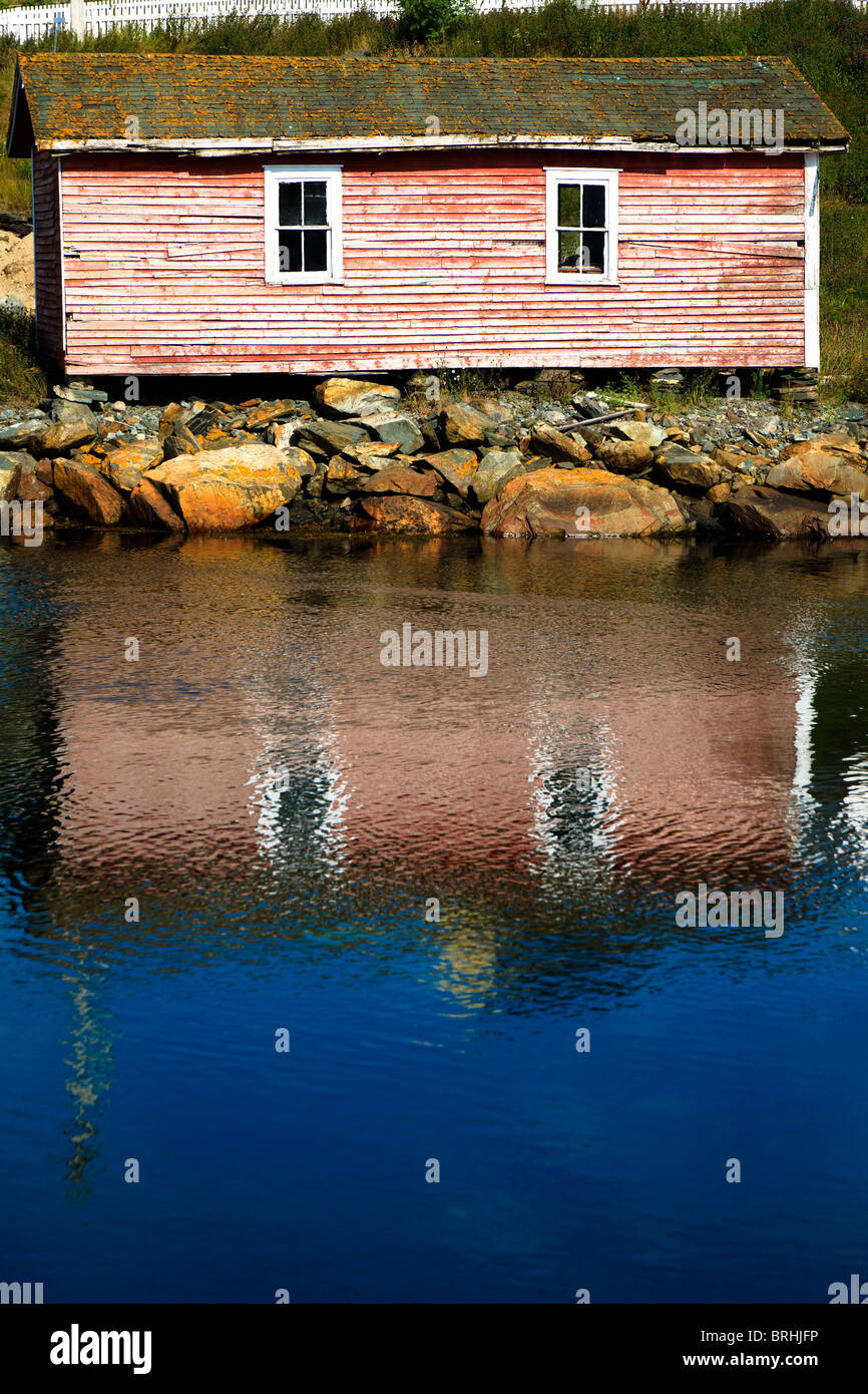 Faded old wooden building at edge of Harbour Pond in Brigus, Newfoundland, Canada Stock Photo