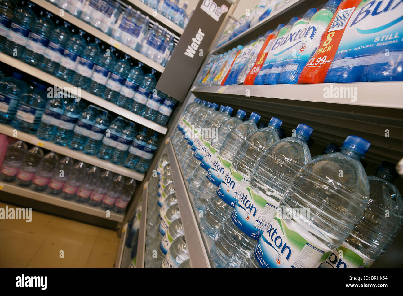 Bottled mineral water for sale in a supermarket stacked on shelf, UK Stock Photo
